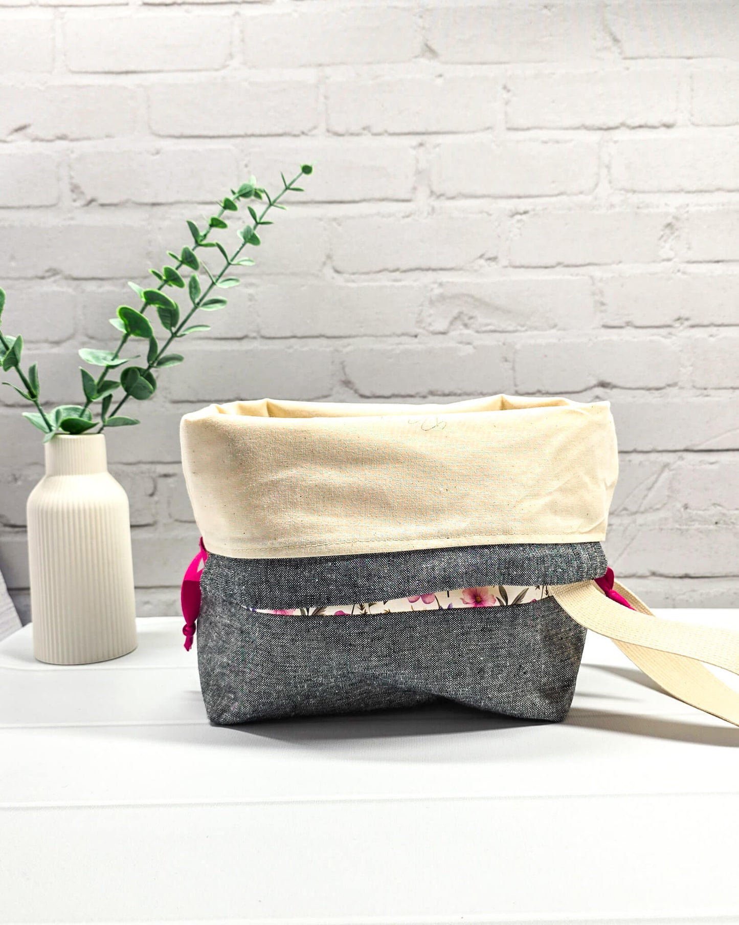 Handgenähte Projekttasche mit zartem Blumenmuster in Pink und Lila auf hellem Stoff mit graumeliertem Boden. Handmade in Bayern von Nadelmikado.
