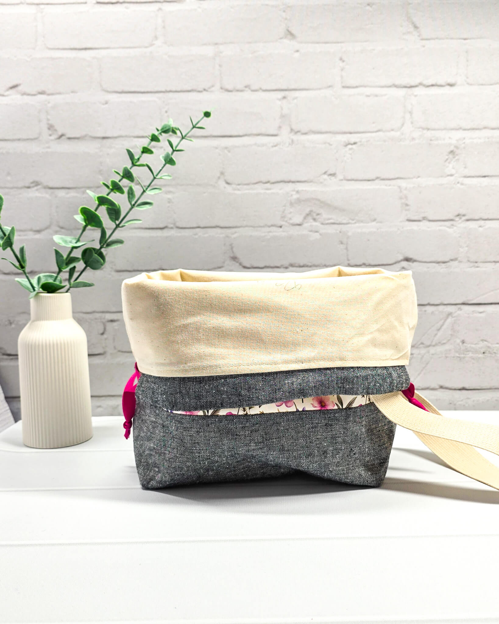 Handgenähte Projekttasche mit zartem Blumenmuster in Pink und Lila auf hellem Stoff mit graumeliertem Boden. Handmade in Bayern von Nadelmikado.