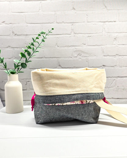 Handgenähte Projekttasche mit zartem Blumenmuster in Pink und Lila auf hellem Stoff mit graumeliertem Boden. Handmade in Bayern von Nadelmikado.