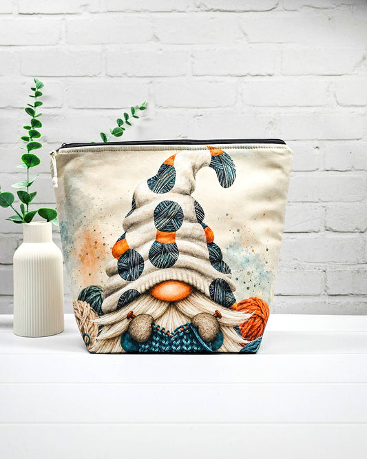 Strickprojekttasche Größe M mit Wichtel, heller Mütze und Wollknäueln in Petrol, Orange und Dunkelgrau sowie schwarzem Reißverschluss. Handgenäht in Bayern von Nadelmikado.