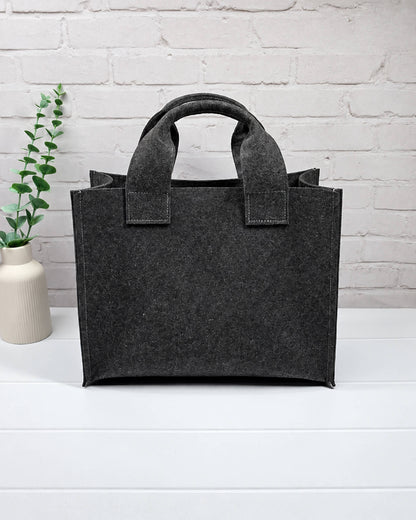 Stricktasche Größe M aus anthrazitfarbenem Filz mit großer bordeauxroter Außentasche und zwei kurzen Henkeln. Handgenäht in Bayern von Nadelmikado.