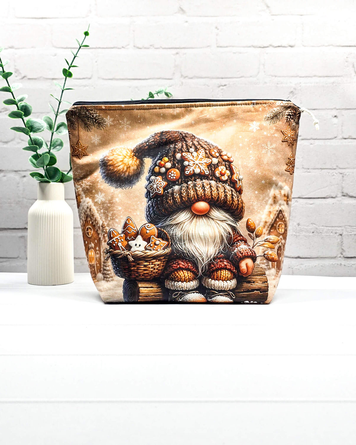 Projekttasche Isvind Größe M mit Weihnachtswichtel, Korb voller Lebkuchen, verschneitem Winterdorf und warmen Beige- und Brauntönen. Mit Reißverschluss für Strickprojekte bis 400 g Wolle. Handgenäht in Bayern von Nadelmikado.