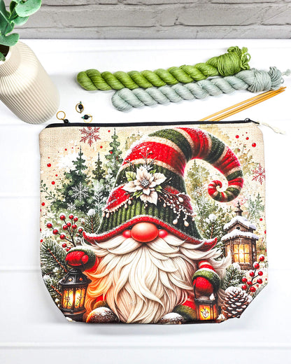 Projekttasche Isvind Größe M mit Weihnachtswichtel, rot-grüner Zipfelmütze, langem weißem Bart, verschneiten Tannen und leuchtenden Laternen. Mit Reißverschluss für Strickprojekte bis 400 g Wolle. Handgenäht in Bayern von Nadelmikado.