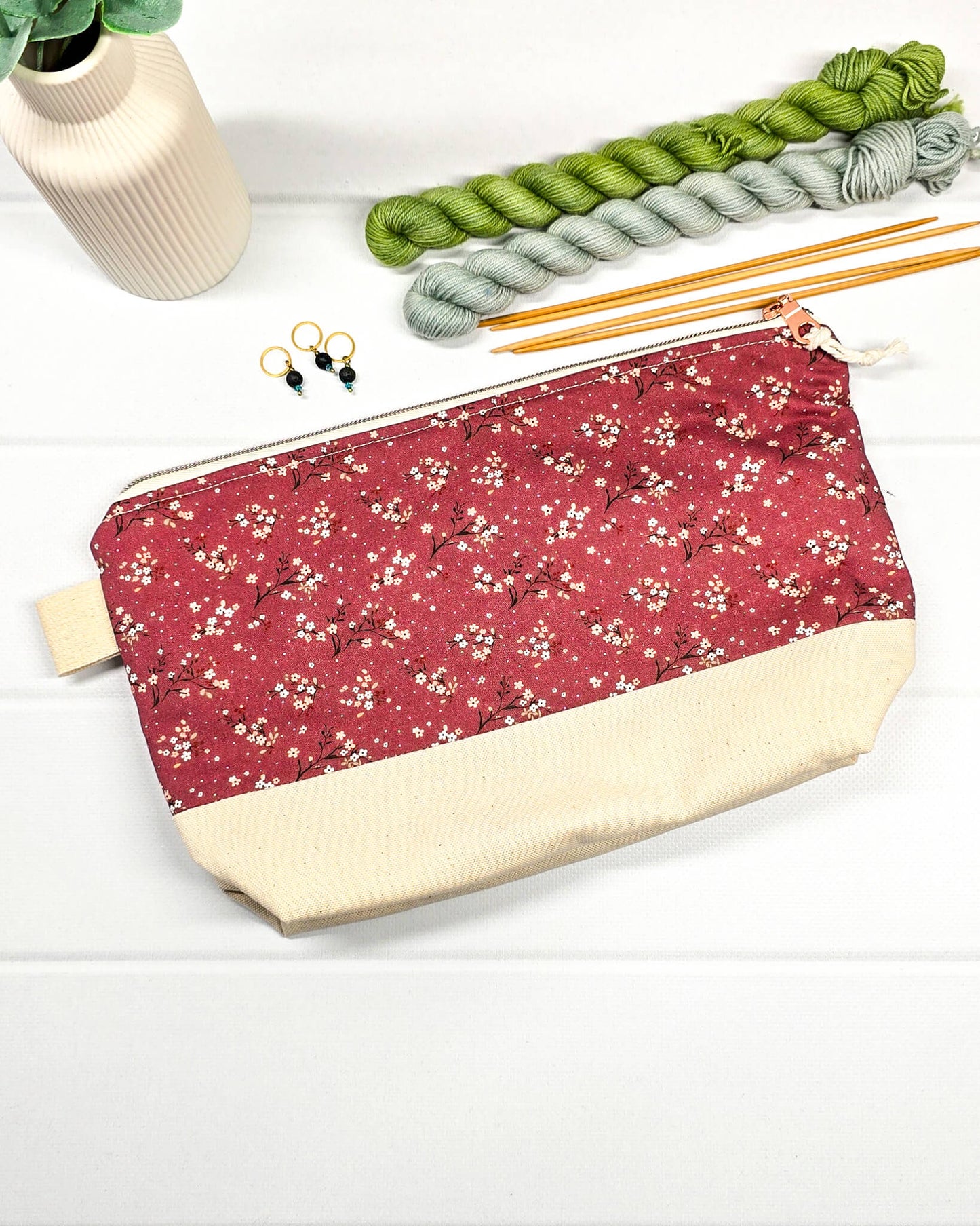 Stricktasche mit beerefarbenem Streublumen-Muster, hellem Canvas-Boden und Reißverschluss. Platz für 200g Wolle. Handgenäht in Bayern von Nadelmikado.