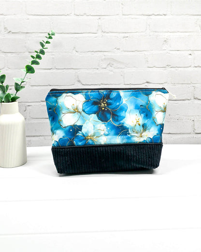 Handgemachte Projekttasche Isvind in Größe S mit blauen Aquarellblüten und einem Taschenboden aus schwarzem Breitcord. Handgenäht in Bayern von Nadelmikado. 