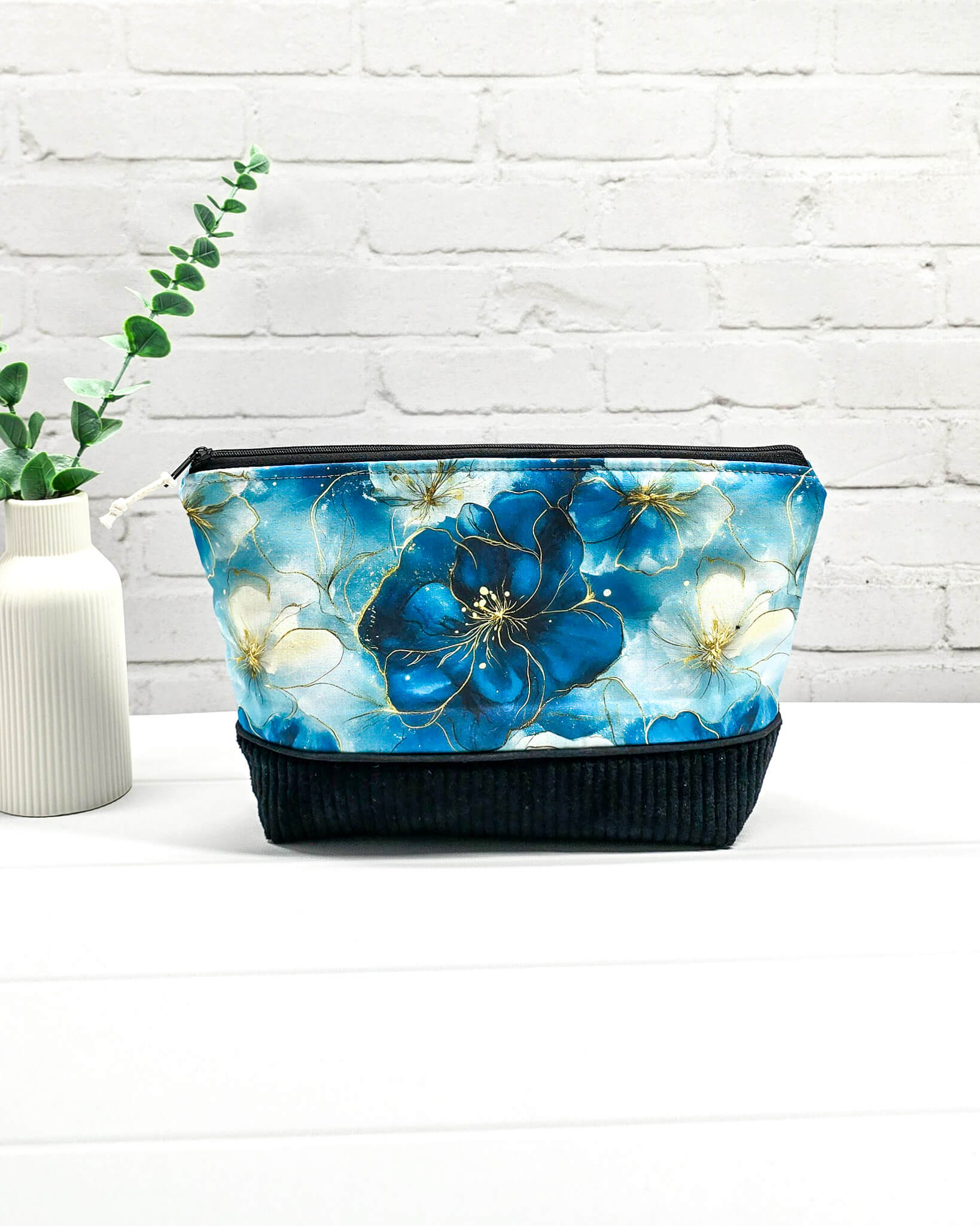 Handgemachte Projekttasche Isvind in Größe S mit blauen Aquarellblüten und einem Taschenboden aus schwarzem Breitcord. Handgenäht in Bayern von Nadelmikado. 