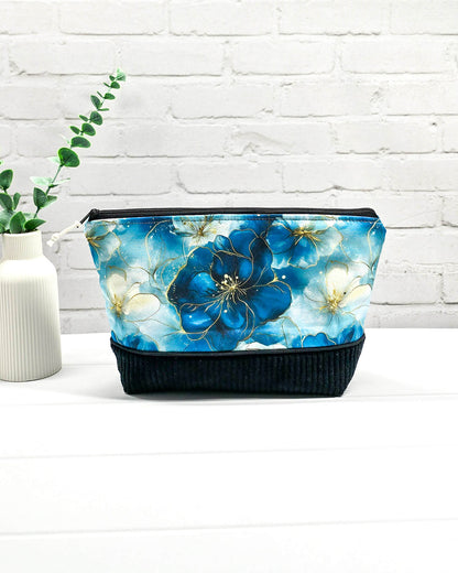 Handgemachte Projekttasche Isvind in Größe S mit blauen Aquarellblüten und einem Taschenboden aus schwarzem Breitcord. Handgenäht in Bayern von Nadelmikado. 