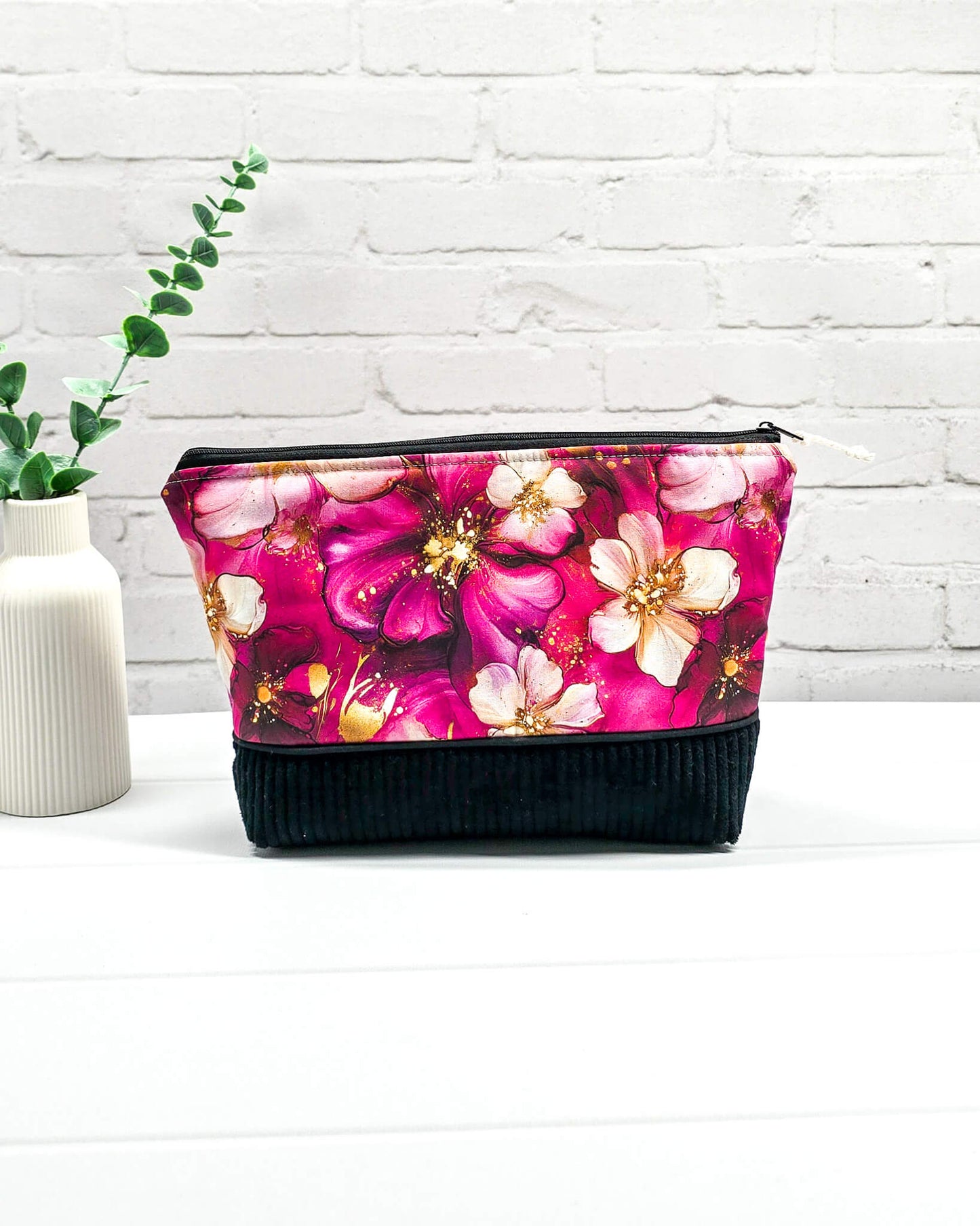 Handgemachte Projekttasche Isvind in Größe S mit magentafarbenen Aquarellblüten, Goldakzenten und einem Taschenboden aus schwarzem Breitcord. Handgenäht in Bayern von Nadelmikado