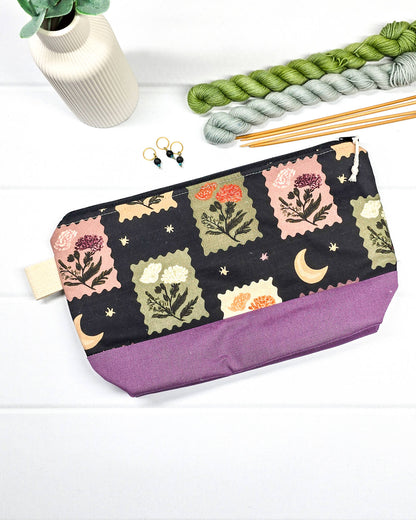 Stricktasche mit Briefmarken- und Blütenmuster, lila Canvas-Boden und Reißverschluss. Platz für 200g Wolle. Handgenäht in Bayern von Nadelmikado.