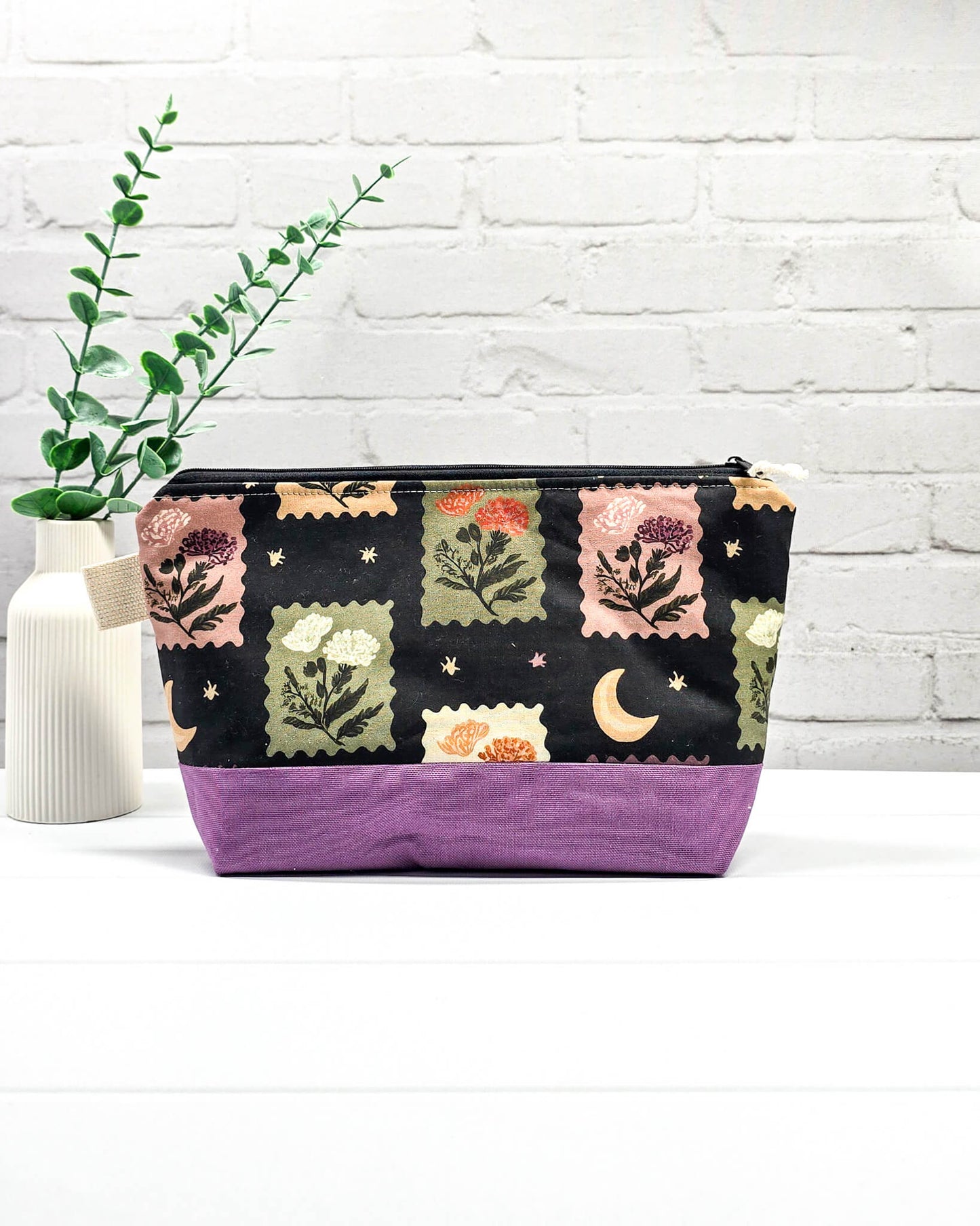 Stricktasche mit Briefmarken- und Blütenmuster, lila Canvas-Boden und Reißverschluss. Platz für 200g Wolle. Handgenäht in Bayern von Nadelmikado.