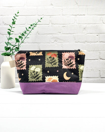 Stricktasche mit Briefmarken- und Blütenmuster, lila Canvas-Boden und Reißverschluss. Platz für 200g Wolle. Handgenäht in Bayern von Nadelmikado.