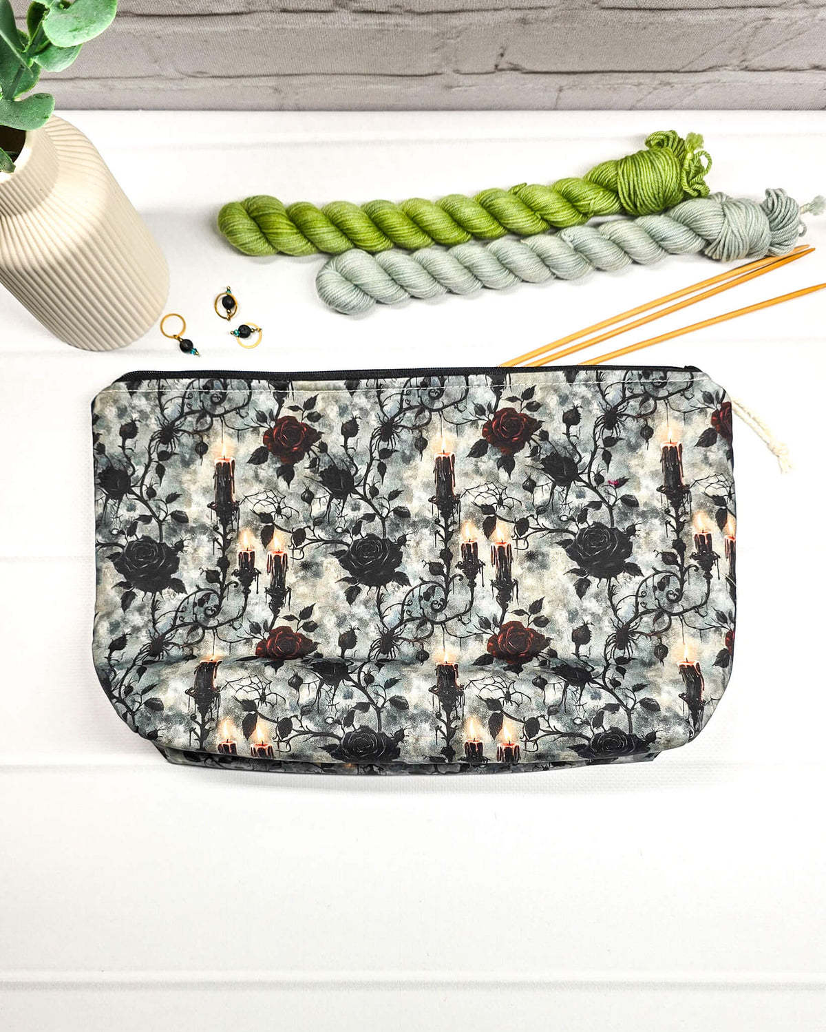 Projekttasche Isvind Größe S mit schwarzen und dunkelroten Rosen, brennenden Kerzen und verschnörkelten Ranken auf grau marmoriertem Stoff. Mit Reißverschluss für Strickprojekte bis 200 g Wolle. Handgenäht in Bayern von Nadelmikado.