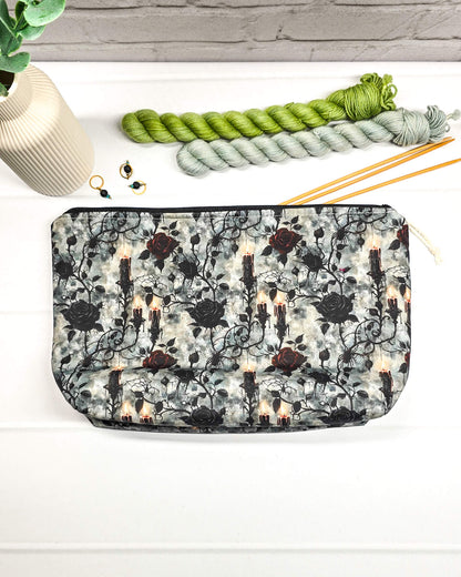 Projekttasche Isvind Größe S mit schwarzen und dunkelroten Rosen, brennenden Kerzen und verschnörkelten Ranken auf grau marmoriertem Stoff. Mit Reißverschluss für Strickprojekte bis 200 g Wolle. Handgenäht in Bayern von Nadelmikado.