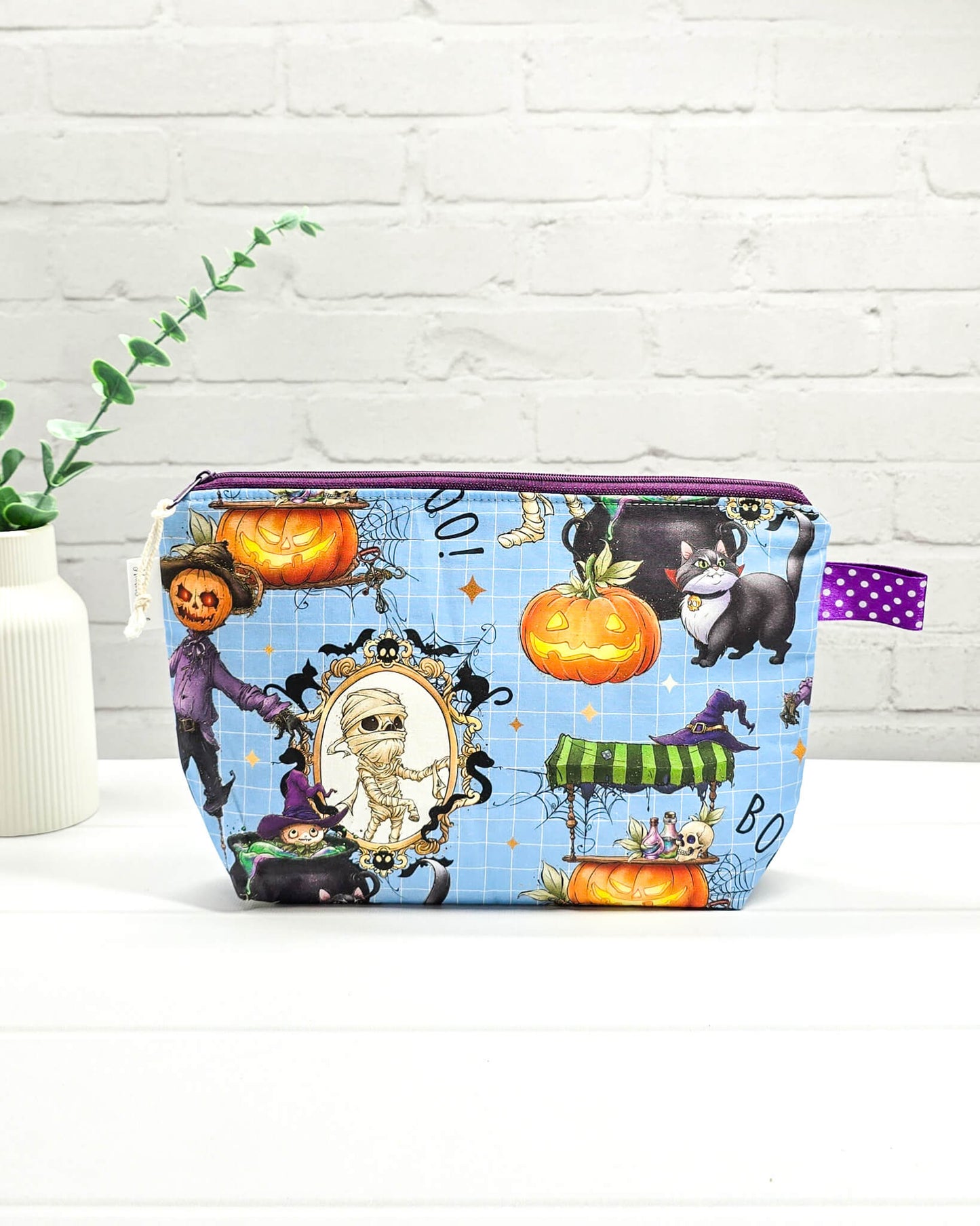 Handgefertigte Projekttasche Isvind S mit bunten Halloween-Motiven, Mumie, schwarzer Katze und Kürbissen auf blauem Hintergrund, kleine Strickzeugtasche - handgenäht in Bayern von Nadelmikado