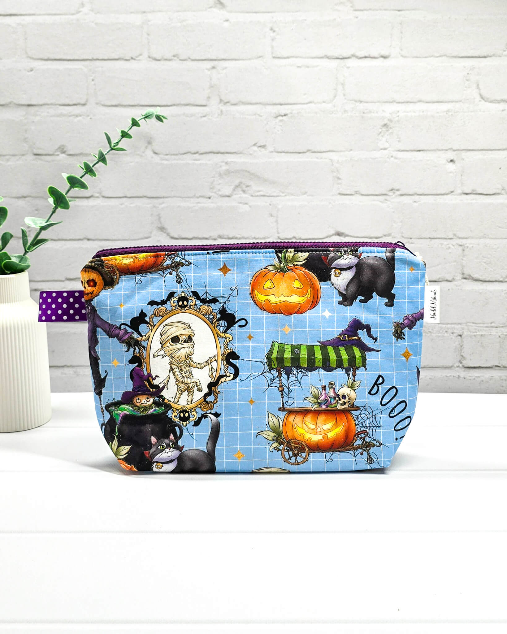 Handgefertigte Projekttasche Isvind S mit bunten Halloween-Motiven, Mumie, schwarzer Katze und Kürbissen auf blauem Hintergrund, kleine Strickzeugtasche - handgenäht in Bayern von Nadelmikado