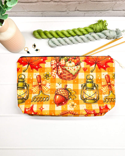 Projekttasche Isvind Größe S mit orangefarbenem Karomuster, Kürbissen, Herbstblättern, Eicheln und leuchtenden Laternen. Reißverschlusstasche für Strickprojekte bis 200 g Wolle. Handgenäht in Bayern von Nadelmikado.