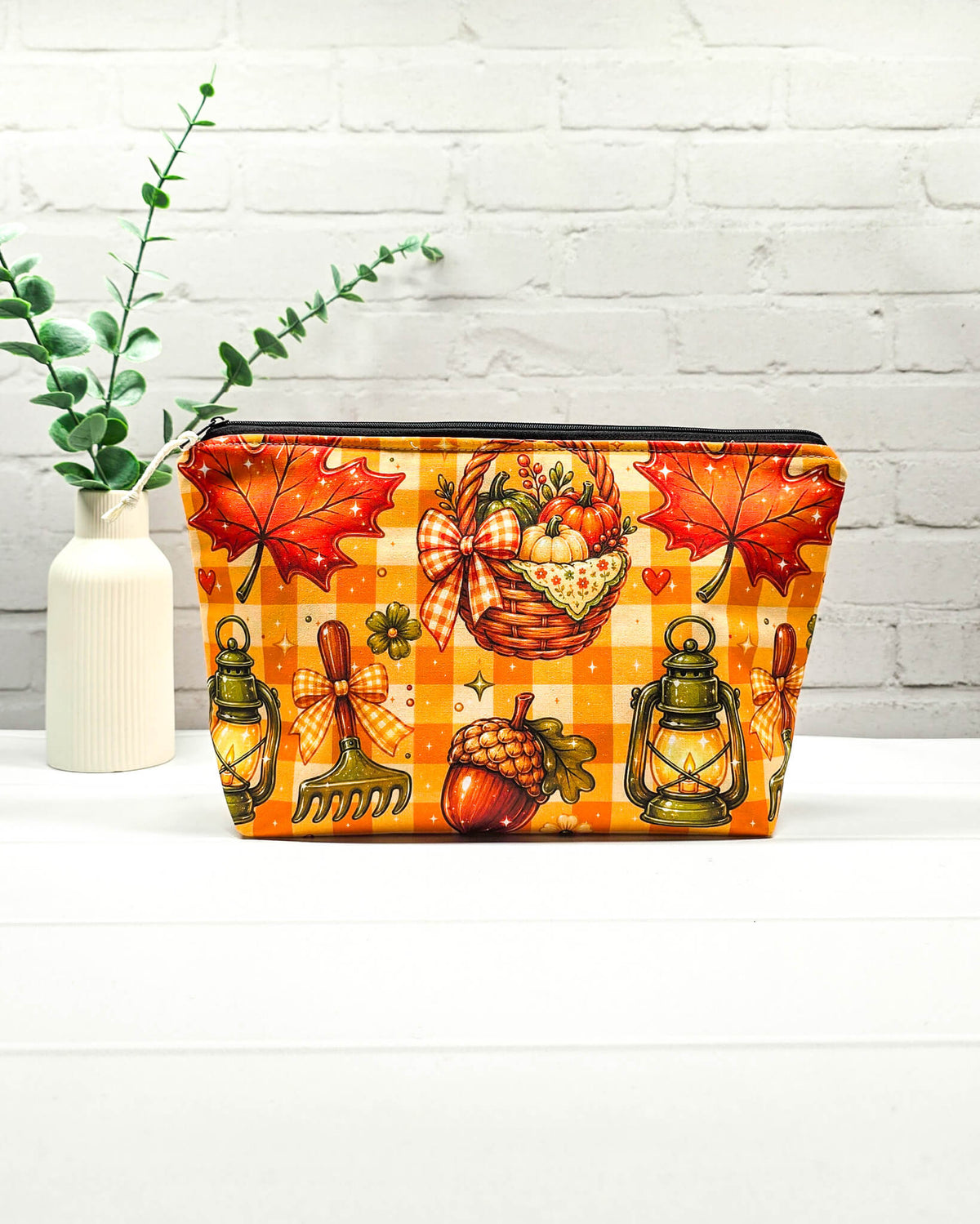 Projekttasche Isvind Größe S mit orangefarbenem Karomuster, Kürbissen, Herbstblättern, Eicheln und leuchtenden Laternen. Reißverschlusstasche für Strickprojekte bis 200 g Wolle. Handgenäht in Bayern von Nadelmikado.