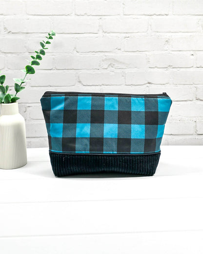 Handgemachte Projekttasche Isvind in Größe S mit blau-schwarzem Karomuster und einem Taschenboden aus schwarzem Breitcord. Handgenäht in Bayern von Nadelmikado. 