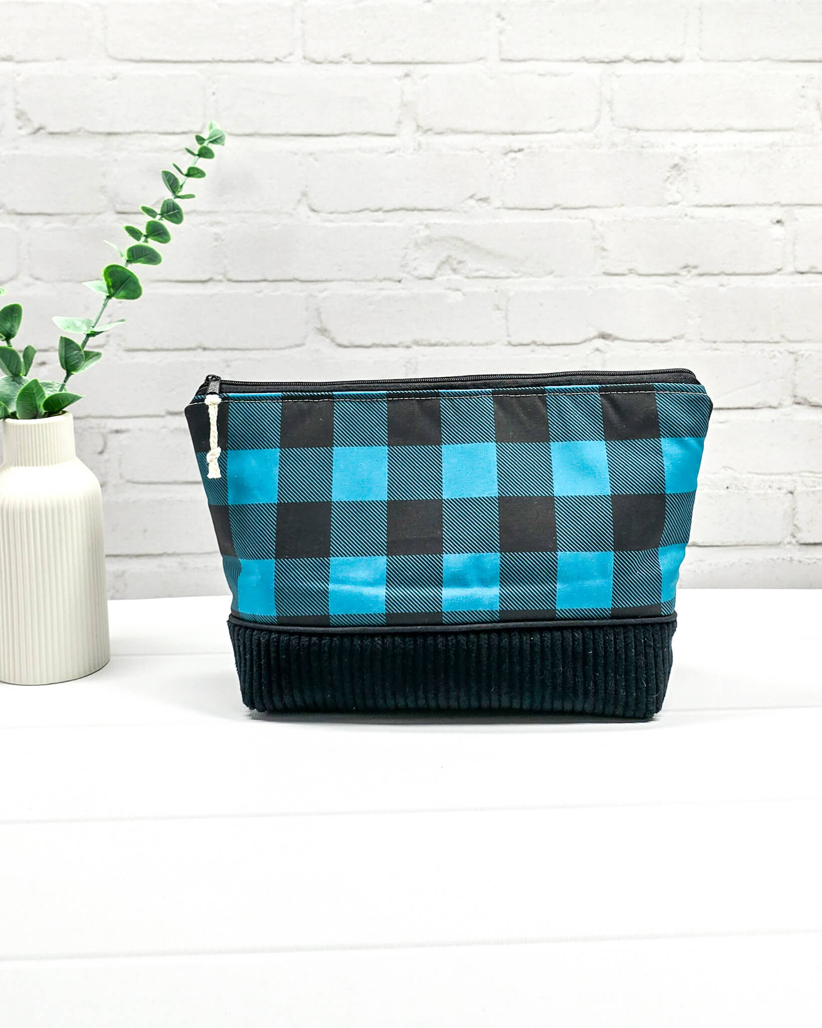 Handgemachte Projekttasche Isvind in Größe S mit blau-schwarzem Karomuster und einem Taschenboden aus schwarzem Breitcord. Handgenäht in Bayern von Nadelmikado. 