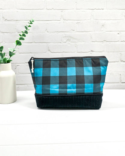 Handgemachte Projekttasche Isvind in Größe S mit blau-schwarzem Karomuster und einem Taschenboden aus schwarzem Breitcord. Handgenäht in Bayern von Nadelmikado. 