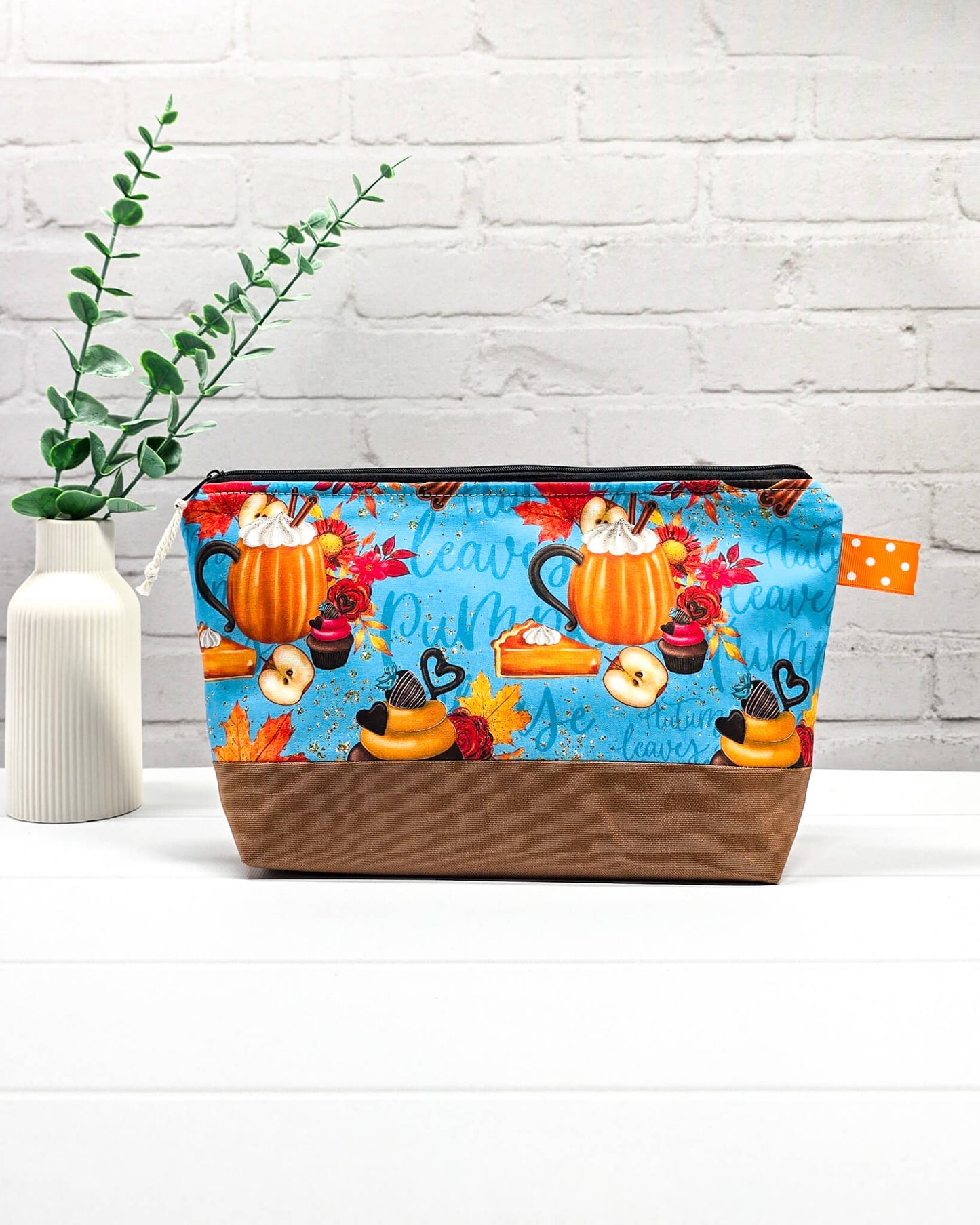 Stricktasche mit Kürbis- und Herbst-Motiv auf Blau, braunem Canvas-Boden und Reißverschluss. Platz für 200g Wolle. Handgenäht in Bayern von Nadelmikado.