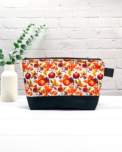 Stricktasche mit Kürbis- und Herbstlaub-Motiv, schwarzem Canvas-Boden und Reißverschluss. Platz für 200g Wolle. Handgenäht in Bayern von Nadelmikado.