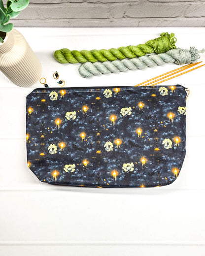 Projekttasche Isvind Größe S aus dunkelblau-schwarzem Stoff mit leuchtenden Kerzen, hellen Blüten und geheimnisvollem Muster. Mit Reißverschluss für kleine Strickprojekte. Handgenäht in Bayern von Nadelmikado.