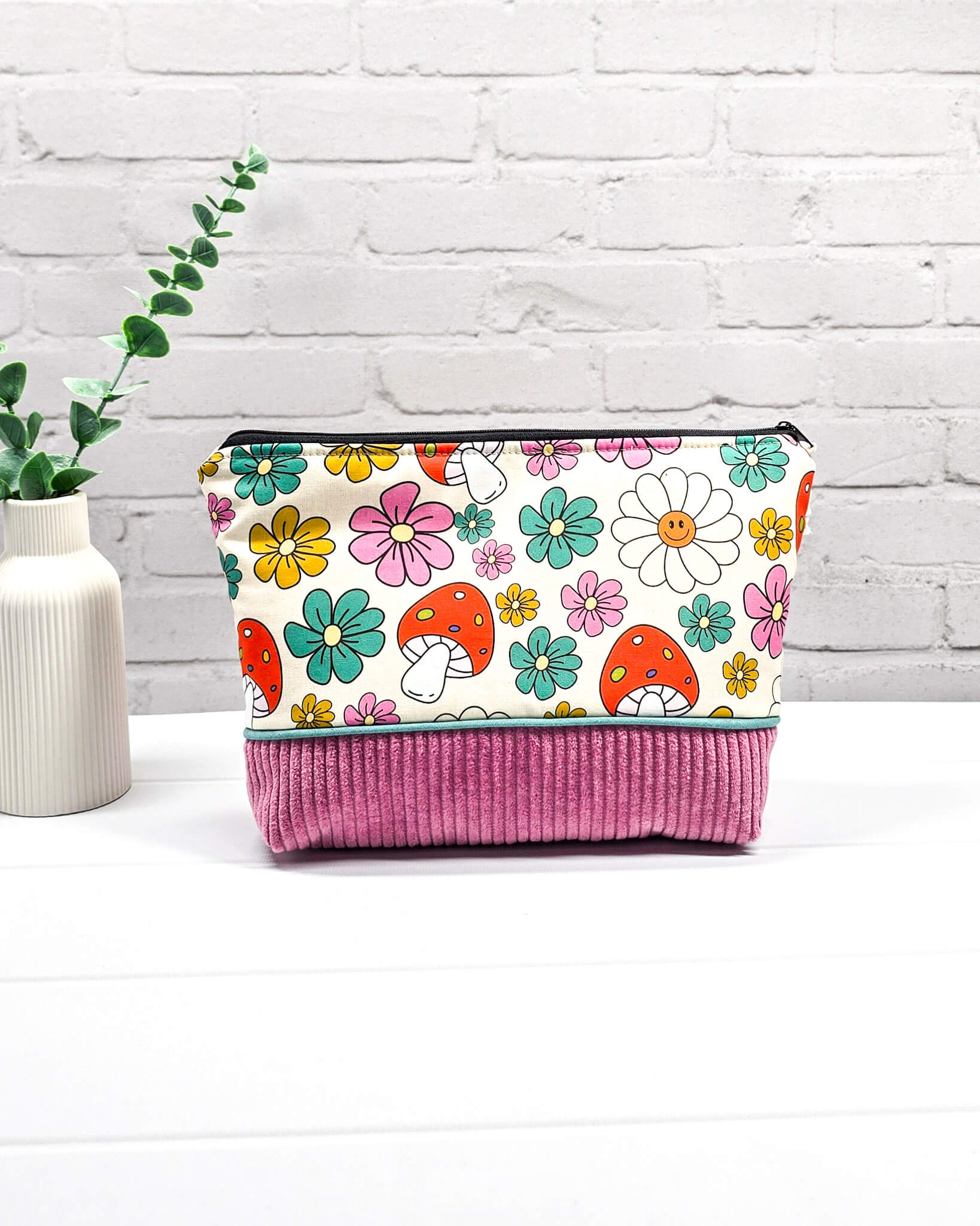 Handgemachte Projekttasche Isvind in Größe S mit bunten Retro-Pilzen und Blumen auf hellem Stoff und einem Taschenboden aus altrosa Breitcord. Handgenäht in Bayern von Nadelmikado