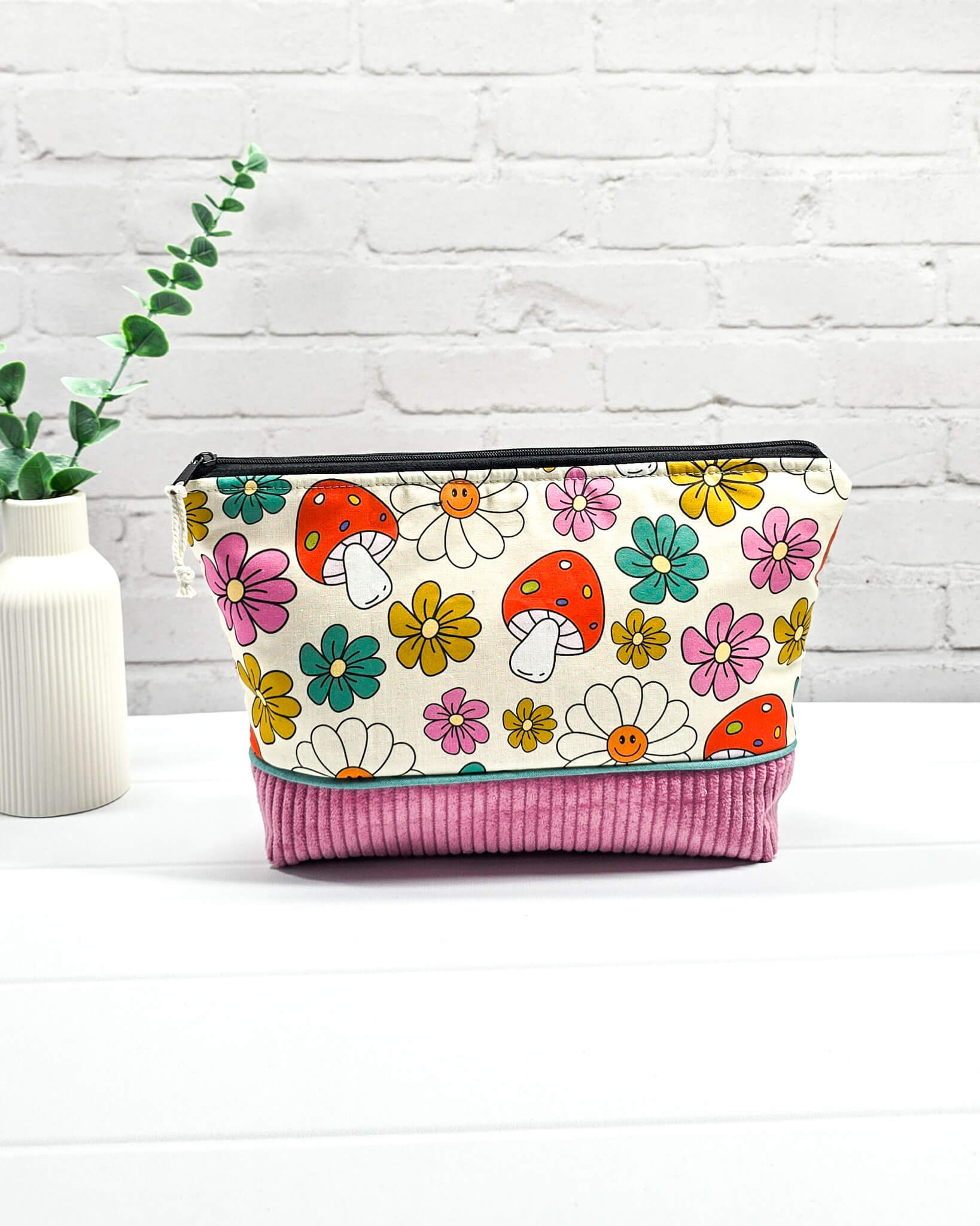 Handgemachte Projekttasche Isvind in Größe S mit bunten Retro-Pilzen und Blumen auf hellem Stoff und einem Taschenboden aus altrosa Breitcord. Handgenäht in Bayern von Nadelmikado