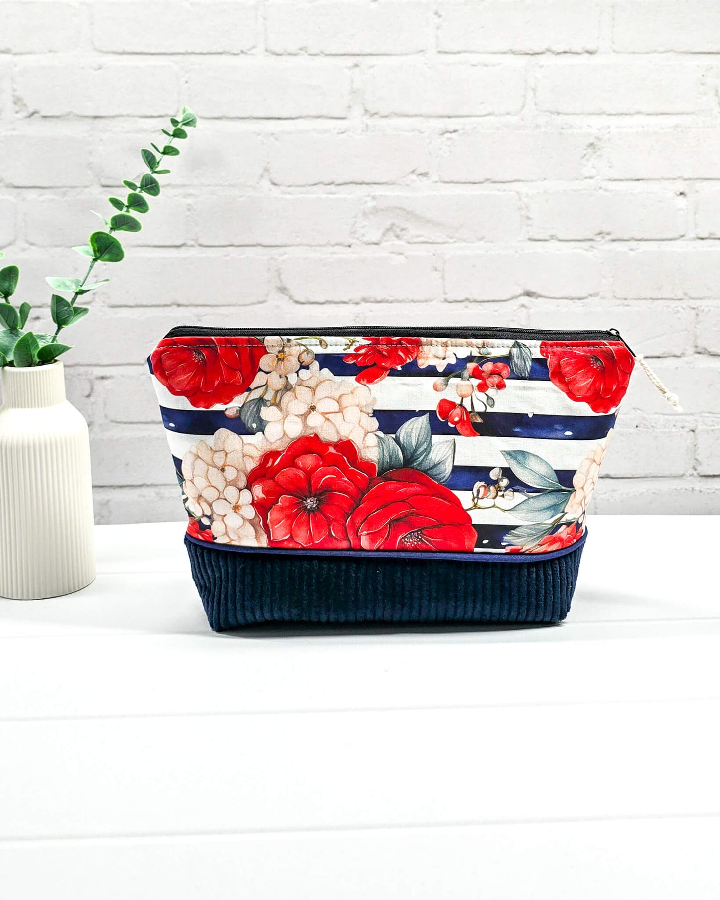 Handgemachte Projekttasche Isvind in Größe S mit roten Rosen auf blau-weiß gestreiftem Stoff und einem Taschenboden aus dunkelblauem Breitcord. Handgenäht in Bayern von Nadelmikado.