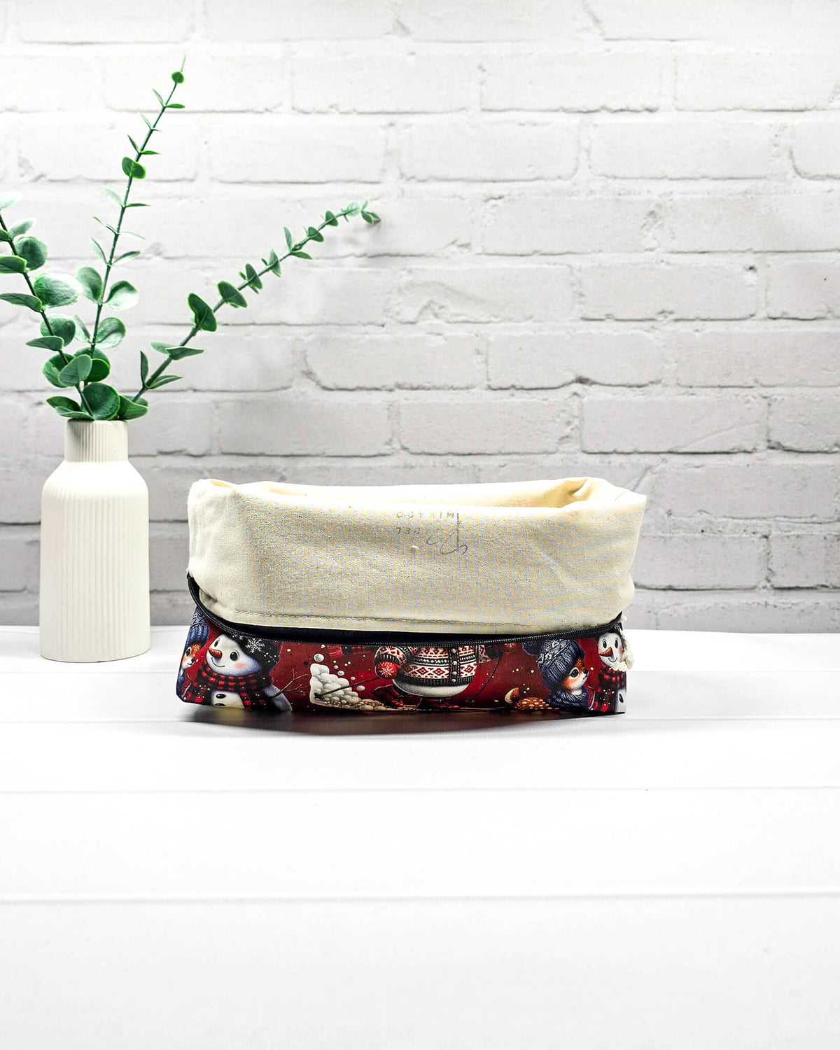 Projekttasche Isvind Größe S mit Schneemännern, kleinen Rehen, Laternen und winterlichem Motiv in Rot, Schwarz und Weiß. Mit Reißverschluss für kleine Strickprojekte. Handgenäht in Bayern von Nadelmikado.
