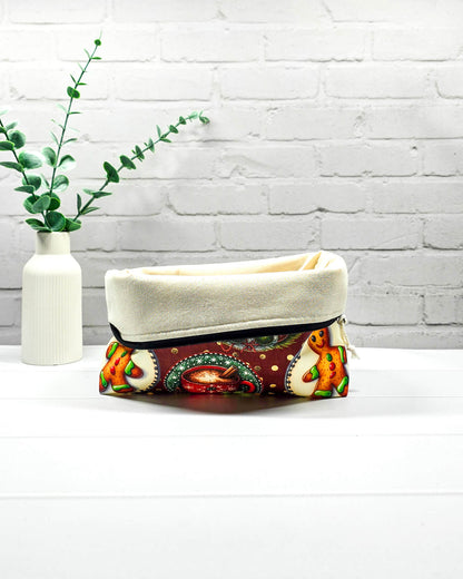 Projekttasche Isvind Größe S mit Weihnachtswichtel, Lebkuchenmännchen, geschmückten Tannenbäumen und roter Tasse auf dunkelrotem Stoff mit goldenen Punkten. Mit Reißverschluss für Strickprojekte bis 200 g Wolle. Handgenäht in Bayern von Nadelmikado.