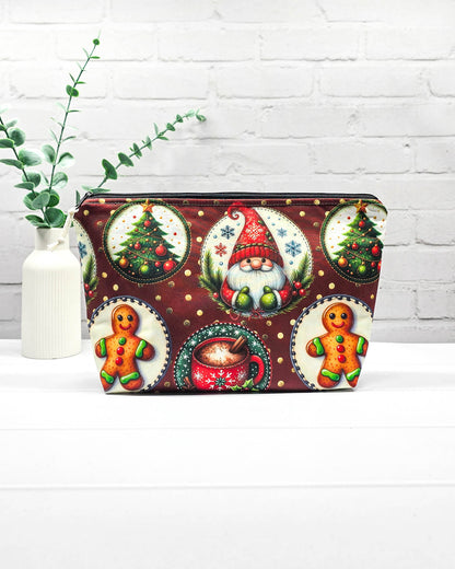 Projekttasche Isvind Größe S mit Weihnachtswichtel, Lebkuchenmännchen, geschmückten Tannenbäumen und roter Tasse auf dunkelrotem Stoff mit goldenen Punkten. Mit Reißverschluss für Strickprojekte bis 200 g Wolle. Handgenäht in Bayern von Nadelmikado.