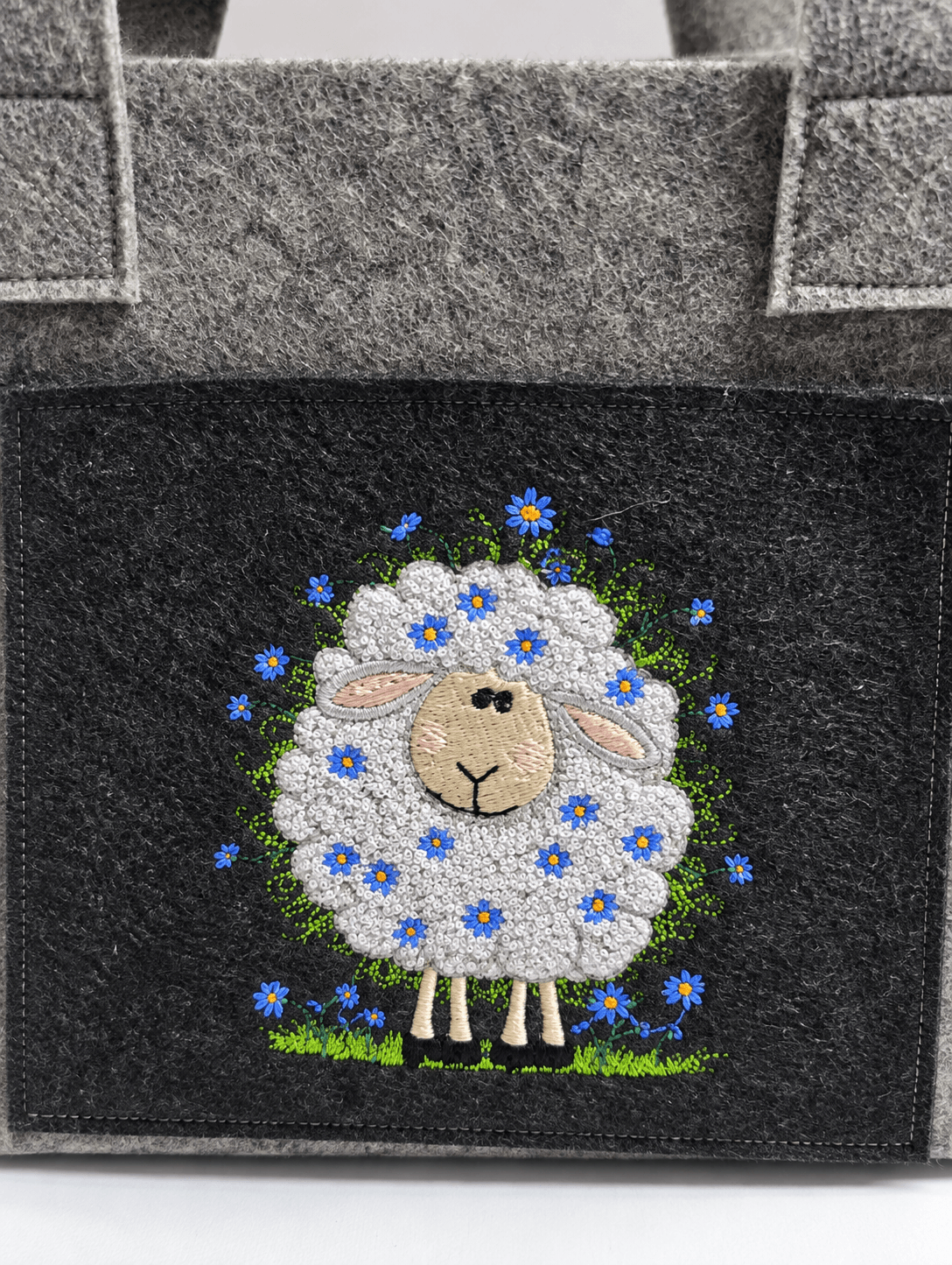 Projekttasche Liv aus dunkelgrauem Filz mit besticktem Blumenschaf – handgenäht in Bayern von NadelMikado