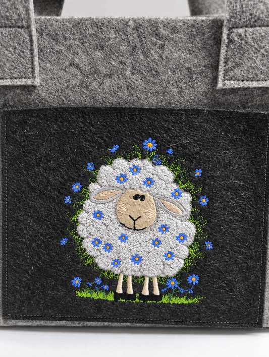 Projekttasche Liv aus dunkelgrauem Filz mit besticktem Blumenschaf – handgenäht in Bayern von NadelMikado
