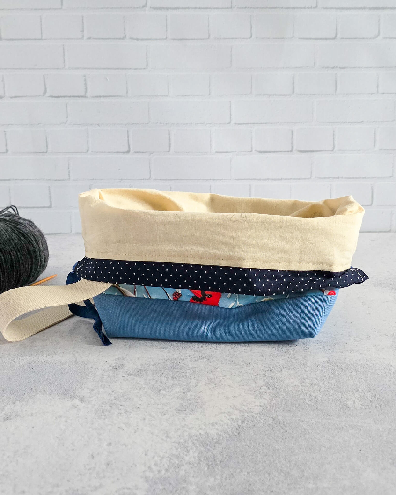 Winterliche Projekttasche mit rotem Vogelmotiv auf blauem Stoff - handgenäht in Bayern von Nadelmikado