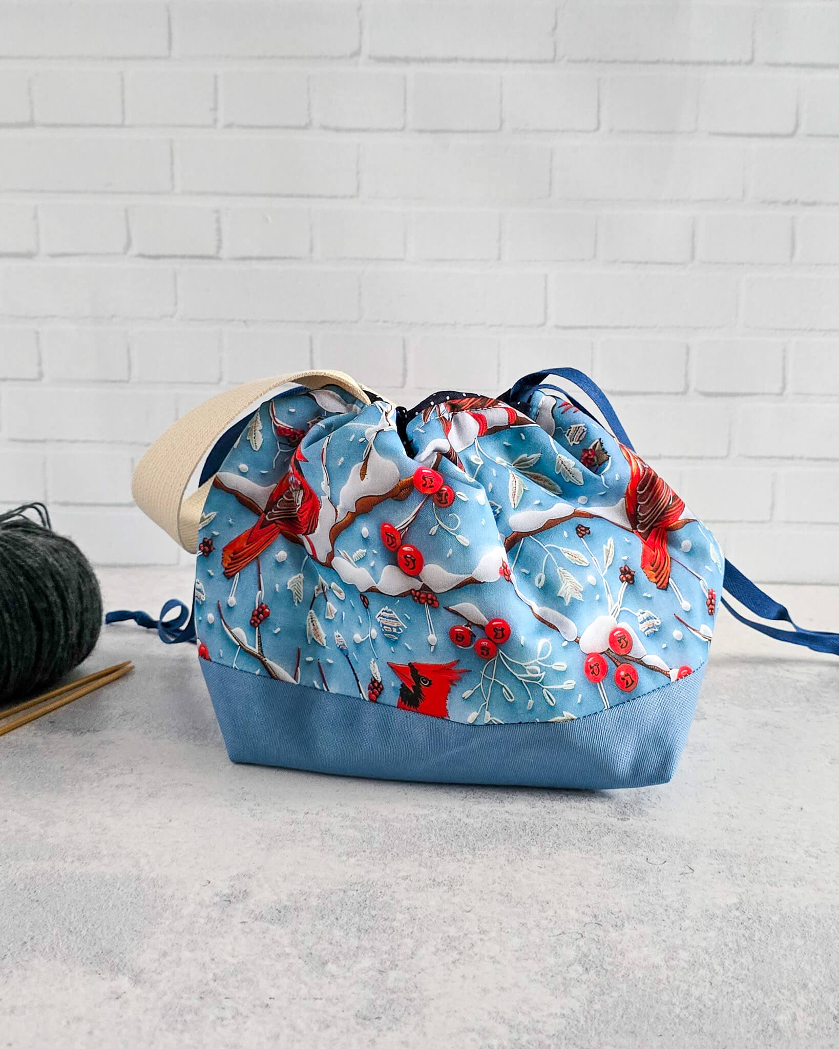 Winterliche Projekttasche mit rotem Vogelmotiv auf blauem Stoff - handgenäht in Bayern von Nadelmikado