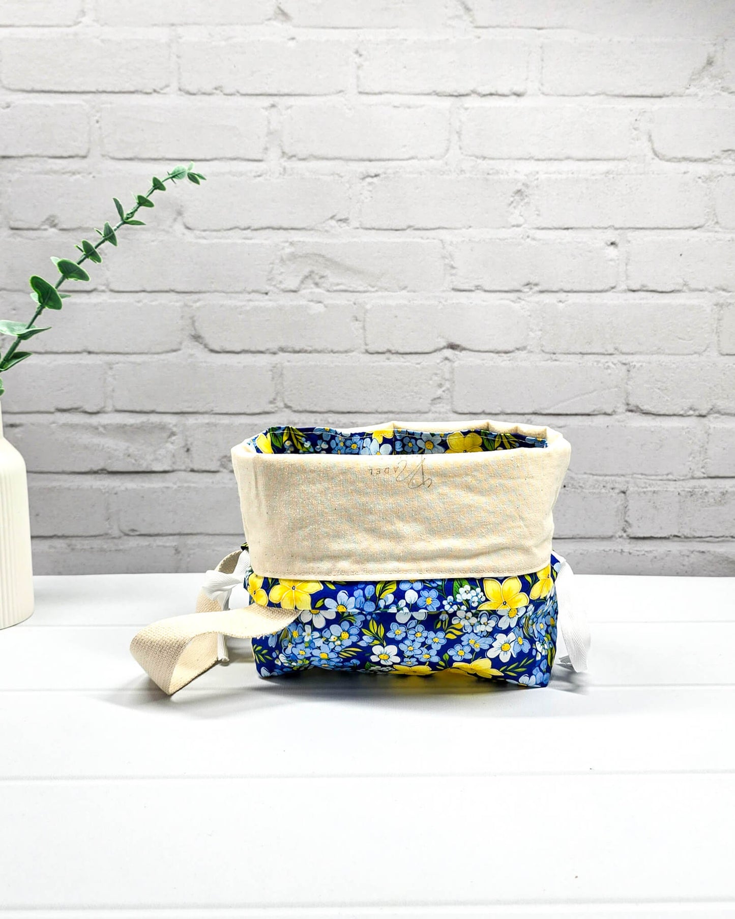 Handgefertigte Stricktasche mit gelben Blumen auf blauem Stoff, bietet Platz für 200g Wolle und Sockenstrickzeug, mit Baumwoll-Tragegurt - handgenäht in Bayern von Nadelmikado