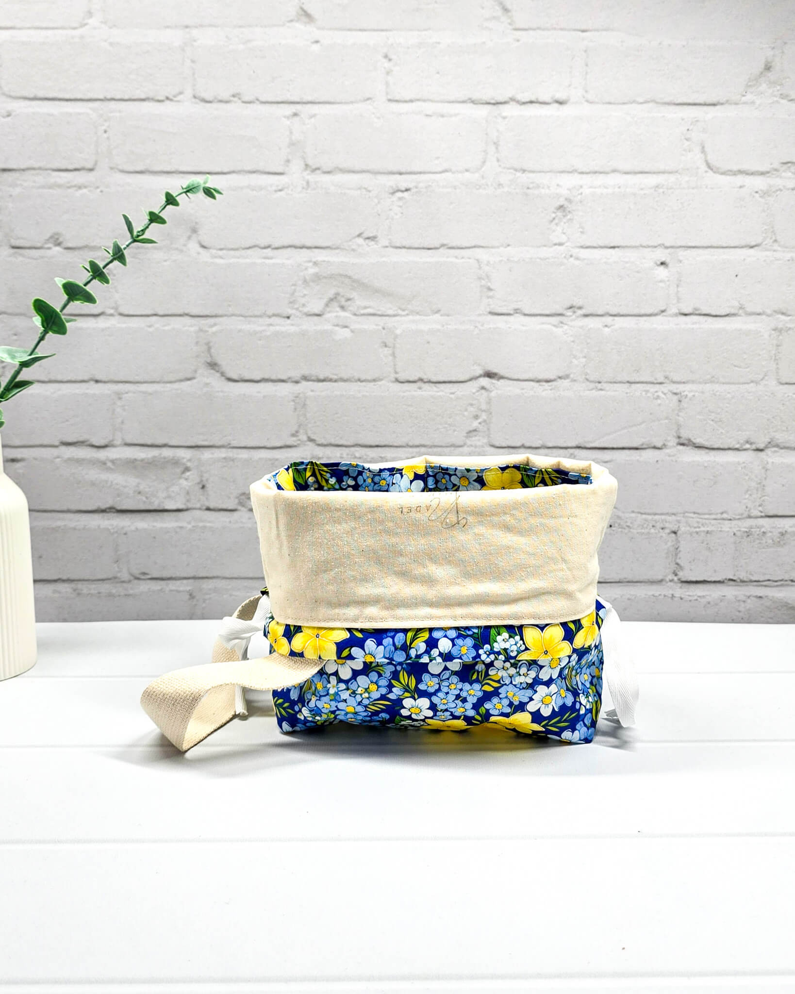 Handgefertigte Stricktasche mit gelben Blumen auf blauem Stoff, bietet Platz für 200g Wolle und Sockenstrickzeug, mit Baumwoll-Tragegurt - handgenäht in Bayern von Nadelmikado