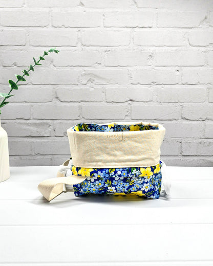 Handgefertigte Stricktasche mit gelben Blumen auf blauem Stoff, bietet Platz für 200g Wolle und Sockenstrickzeug, mit Baumwoll-Tragegurt - handgenäht in Bayern von Nadelmikado