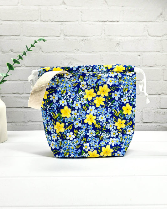 Handgefertigte Stricktasche mit gelben Blumen auf blauem Stoff, bietet Platz für 200g Wolle und Sockenstrickzeug, mit Baumwoll-Tragegurt - handgenäht in Bayern von Nadelmikado