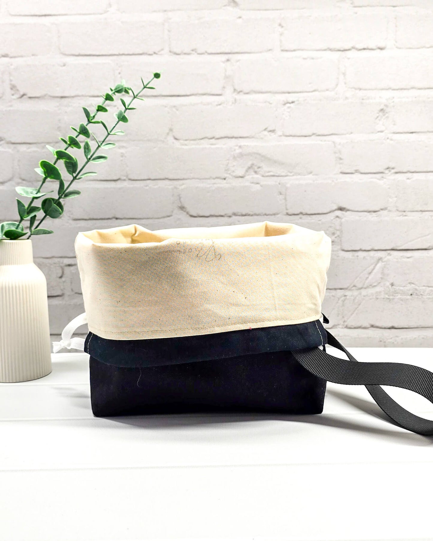Handgenähte Projekttasche mit leuchtend roten Blüten und Schmetterlingen auf dunklem Grund mit schwarzem Boden. Handmade in Bayern von Nadelmikado.