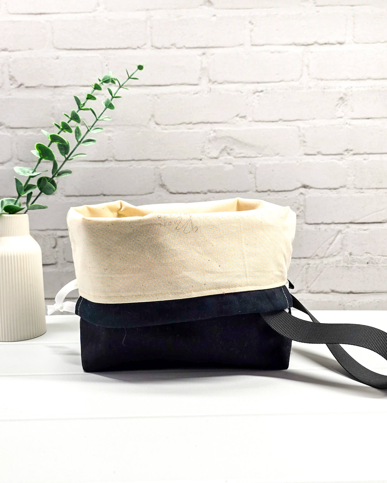 Handgenähte Projekttasche mit leuchtend roten Blüten und Schmetterlingen auf dunklem Grund mit schwarzem Boden. Handmade in Bayern von Nadelmikado.