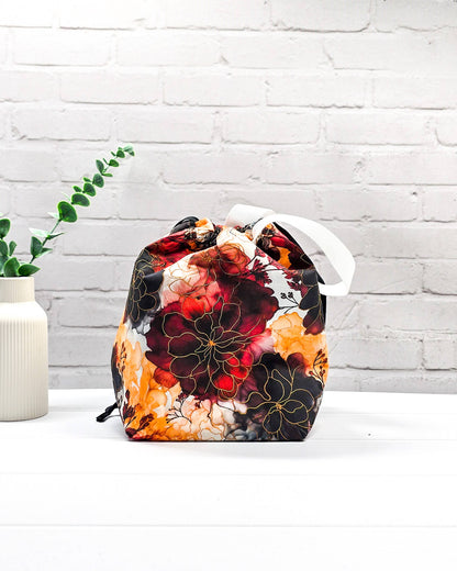 Projekttasche Tuva M aus Baumwolle mit weinroten und senfgelben Aquarell-Blumen, schwarzem Kordelzug und heller Schlaufe. Handgenäht in Bayern von Nadelmikado. 
