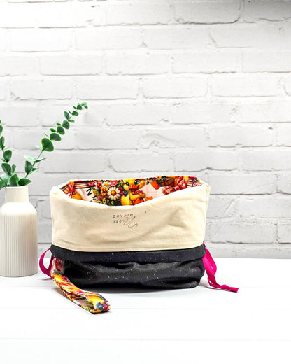 Projekttasche Tuva M aus Baumwolle mit gelben Küken, Blumenmotiven, pinken Zugkordeln und abnehmbarer Handschlaufe. Handgenäht in Bayern von Nadelmikado. 