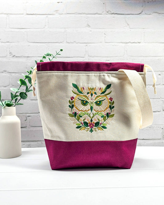 Projekttasche Tuva M aus hellem Canvas und beerefarbenem Stoff mit gesticktem Eulenmotiv, cremefarbenem Kordelzug und Tragegurt. Bietet Platz für 400g Wolle und schützt das Strickzeug vor Verheddern. Handgenäht in Bayern von Nadelmikado.