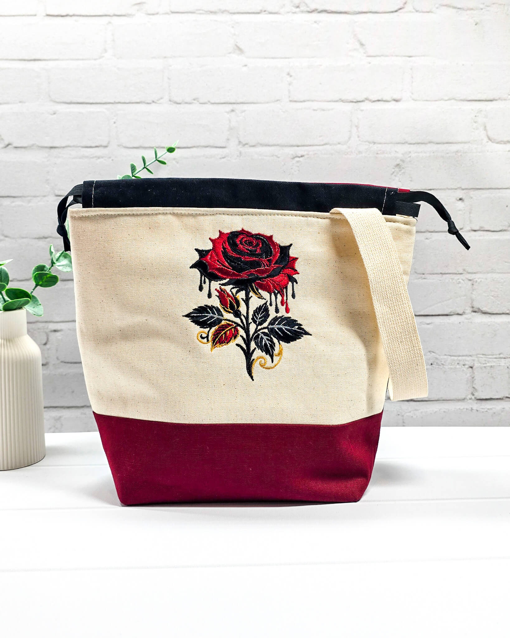 Projekttasche Tuva M aus hellem Canvas und Bordeaux mit gestickter Gothic Rose und schwarzem Kordelzugkragen. Handgenäht in Bayern von Nadelmikado.