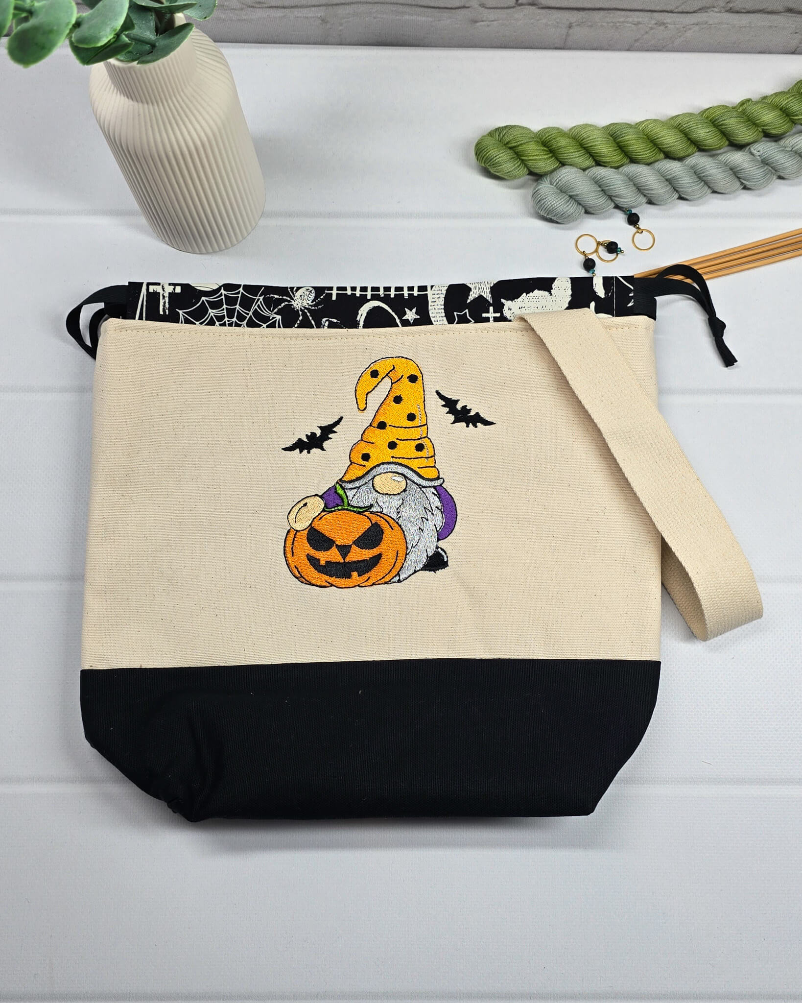Projekttasche Tuva M aus hellem Canvas mit gesticktem Halloween Gnom, Kürbis und schwarzem Kordelzugkragen. Handgenäht in Bayern von Nadelmikado.