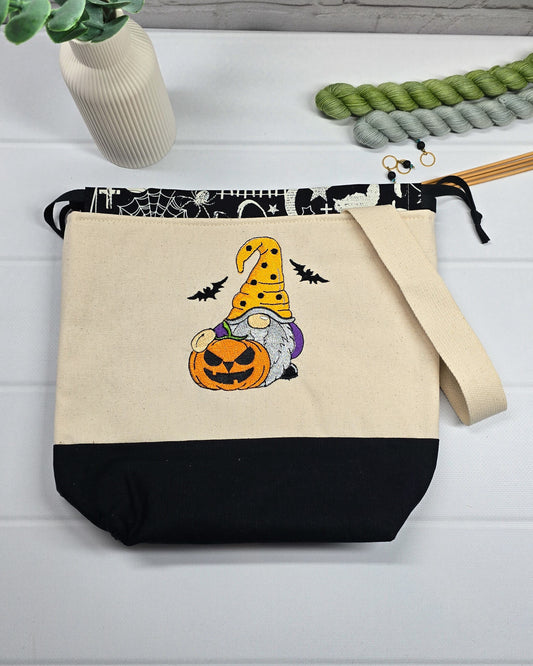 Projekttasche Tuva M aus hellem Canvas mit gesticktem Halloween Gnom, Kürbis und schwarzem Kordelzugkragen. Handgenäht in Bayern von Nadelmikado.