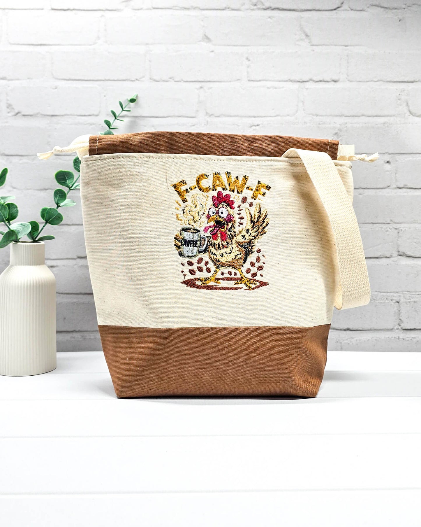 Projekttasche Tuva M aus hellem Canvas und Kaffeebraun mit gesticktem Kaffee-Huhn und Kordelzugverschluss. Handgenäht in Bayern von Nadelmikado.